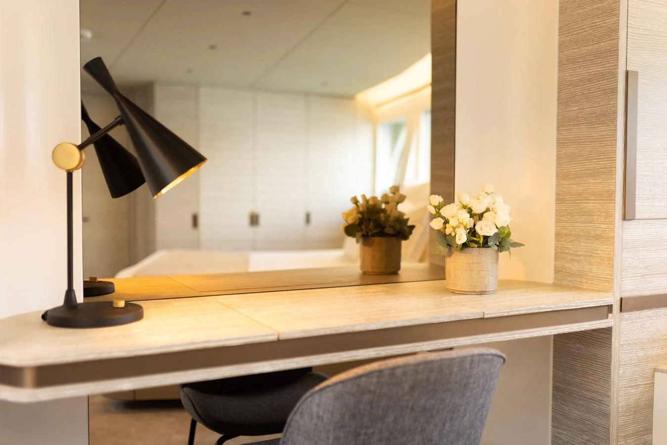 A cozy interior space featuring a modern desk with a stylish lamp and decorative plants. aboard KAMOKA Yacht for Sale