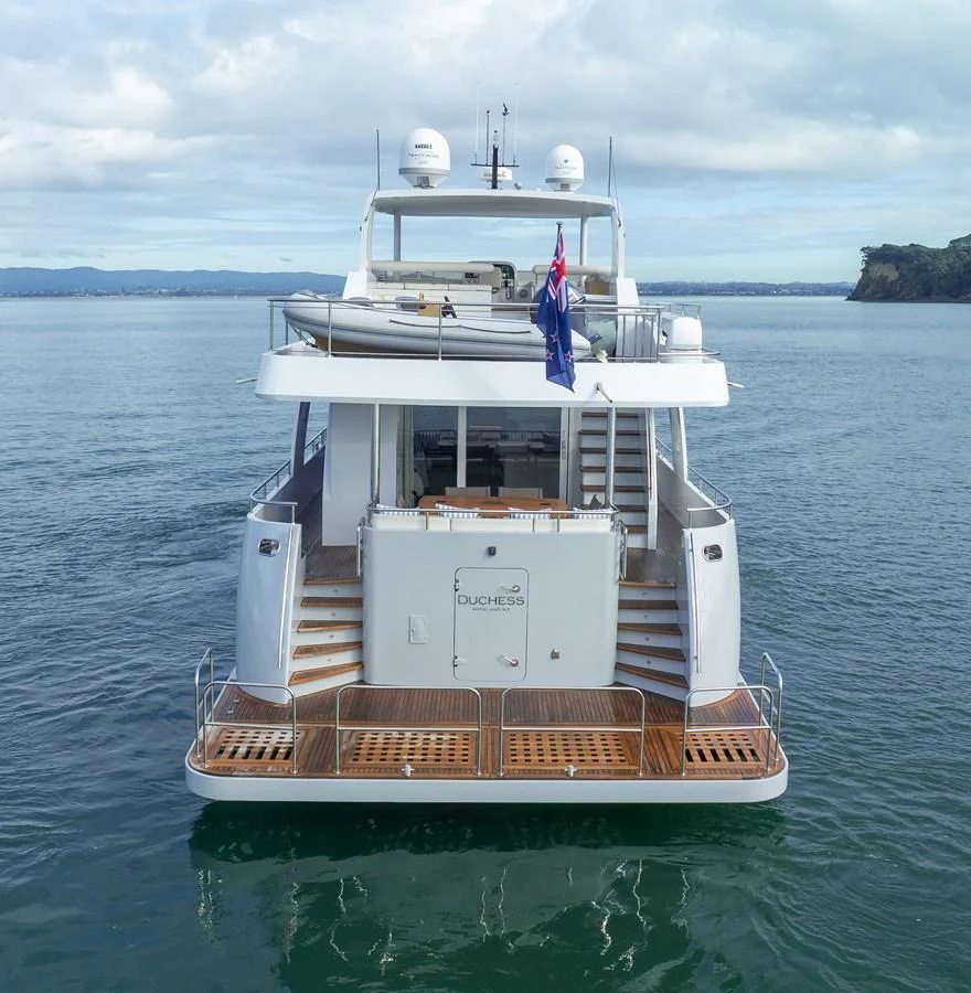 The yacht's aft deck features elegant wooden steps and a spacious swim platform, perfect for easy water access. aboard DUTCHESS Yacht for Sale