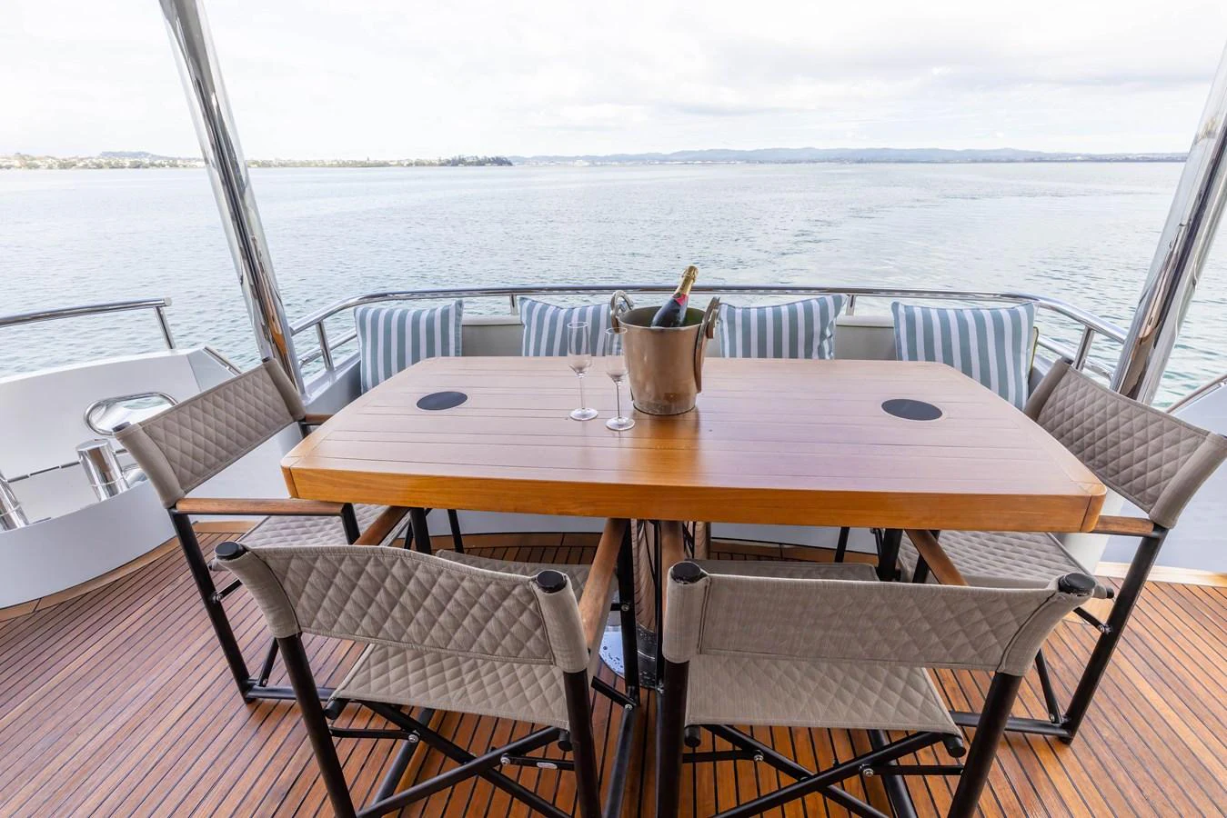 The aft deck features a stylish dining area with a wooden table and comfortable seating, perfect for enjoying meals with a view of the water. aboard DUTCHESS Yacht for Sale
