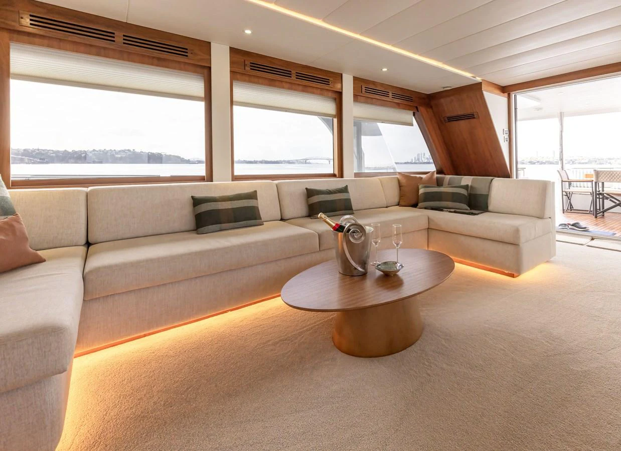 The salon features a spacious and elegant seating area with panoramic windows and ambient lighting. aboard DUTCHESS Yacht for Sale