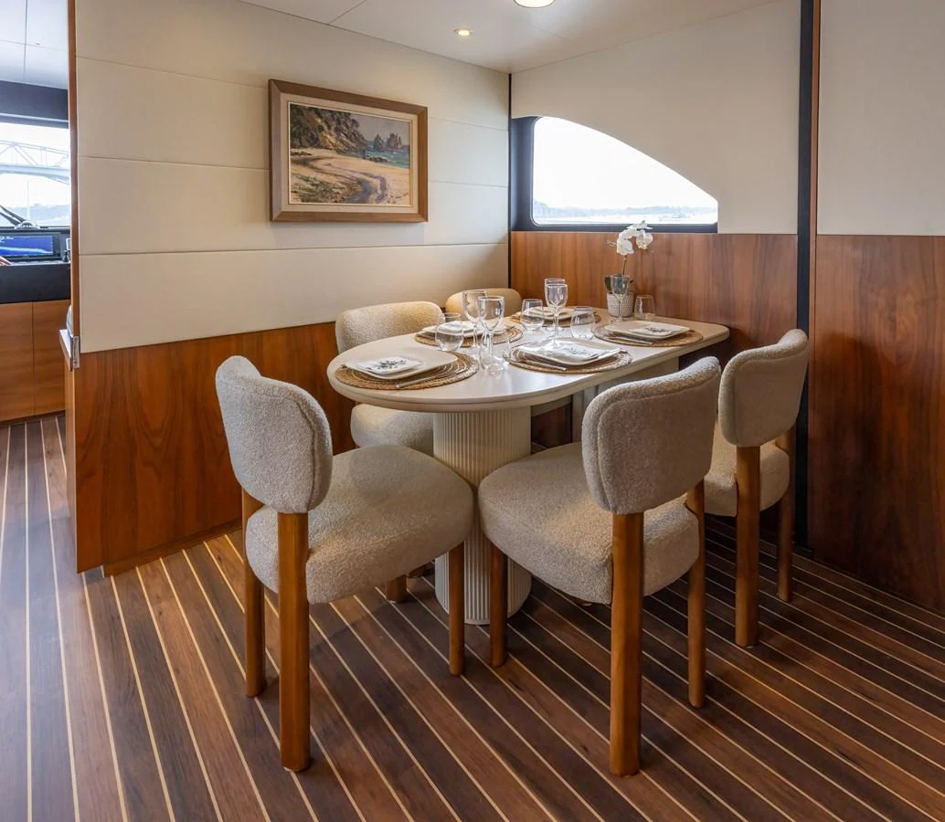The yacht's dining area features a cozy table setup with elegant place settings and comfortable seating. aboard DUTCHESS Yacht for Sale