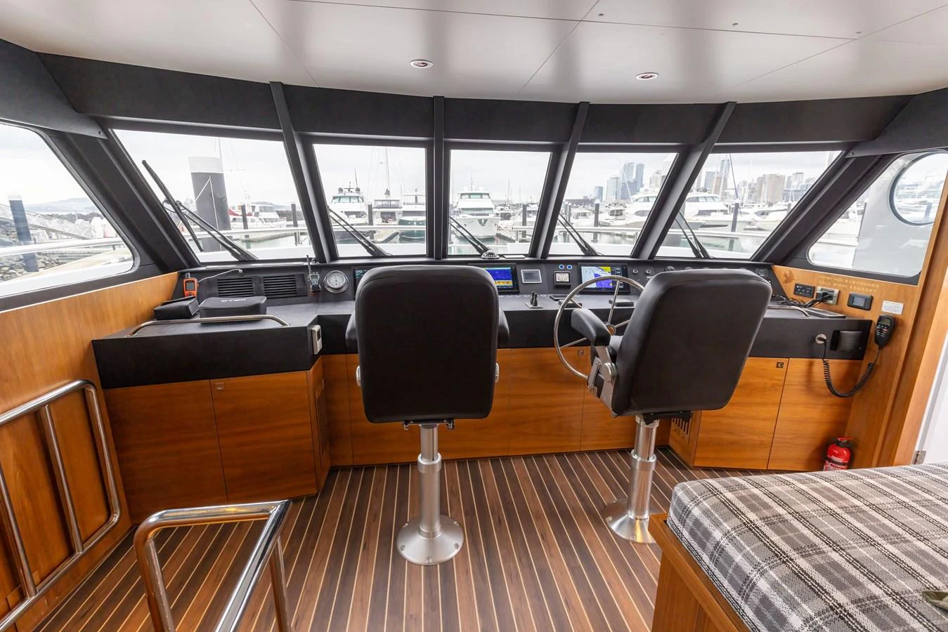 The helm station features modern navigation equipment and comfortable seating with a panoramic view of the marina. aboard DUTCHESS Yacht for Sale