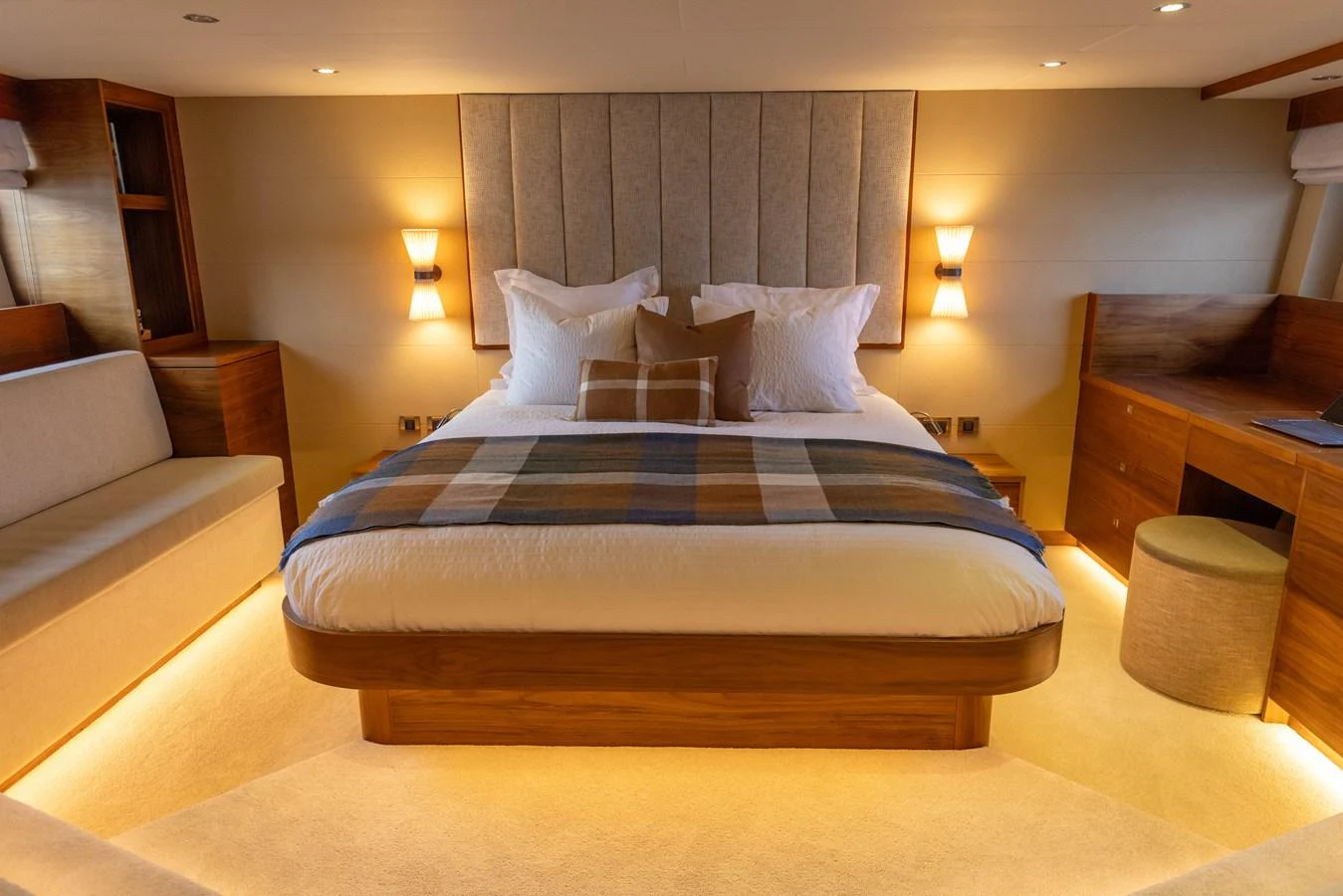 The master stateroom features a luxurious bed with elegant lighting and warm wood accents. aboard DUTCHESS Yacht for Sale