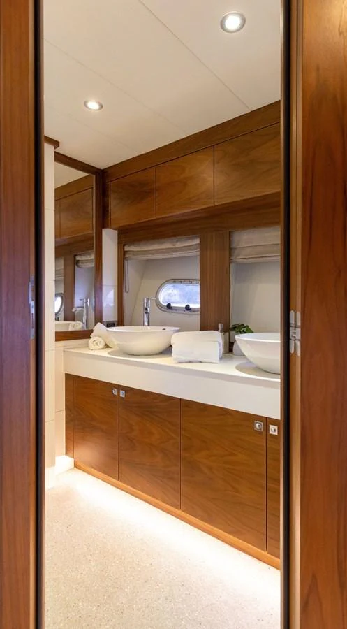 The yacht's bathroom features elegant wood cabinetry and modern fixtures. aboard DUTCHESS Yacht for Sale
