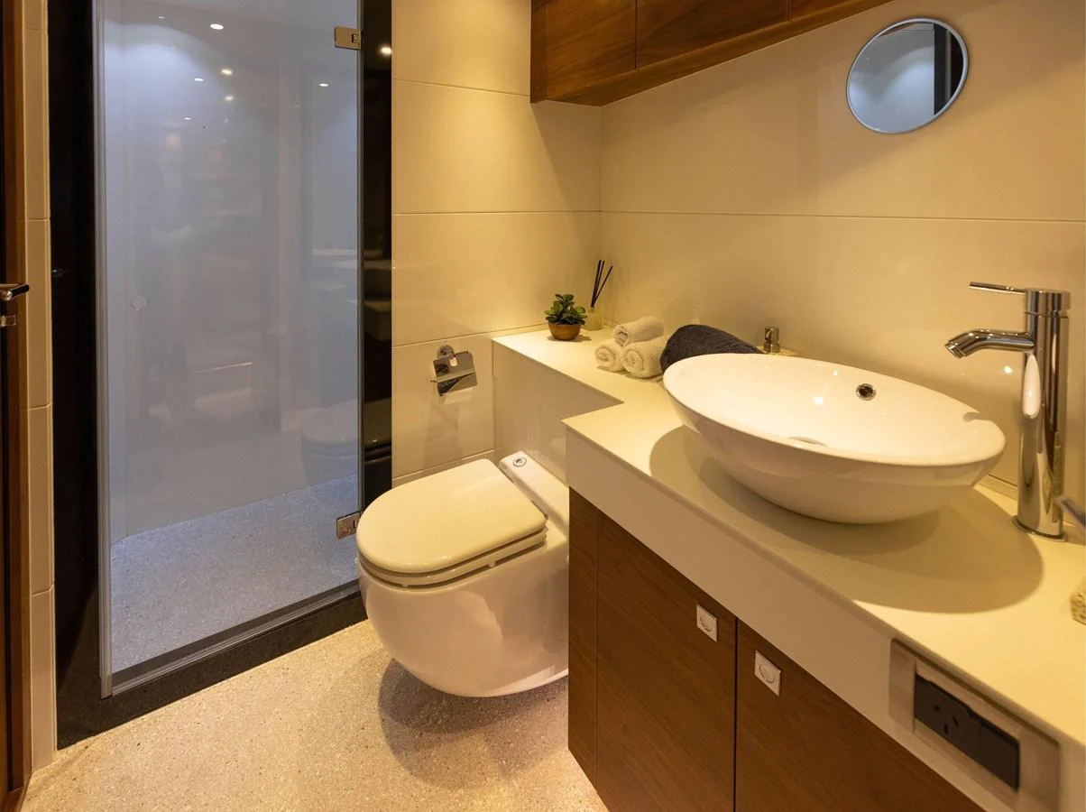 A modern yacht bathroom featuring a sleek design with a vessel sink and a walk-in shower. aboard DUTCHESS Yacht for Sale