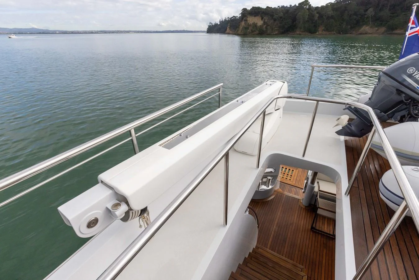 The aft deck offers a serene view of the surrounding waters with elegant wooden flooring and stainless steel railings. aboard DUTCHESS Yacht for Sale