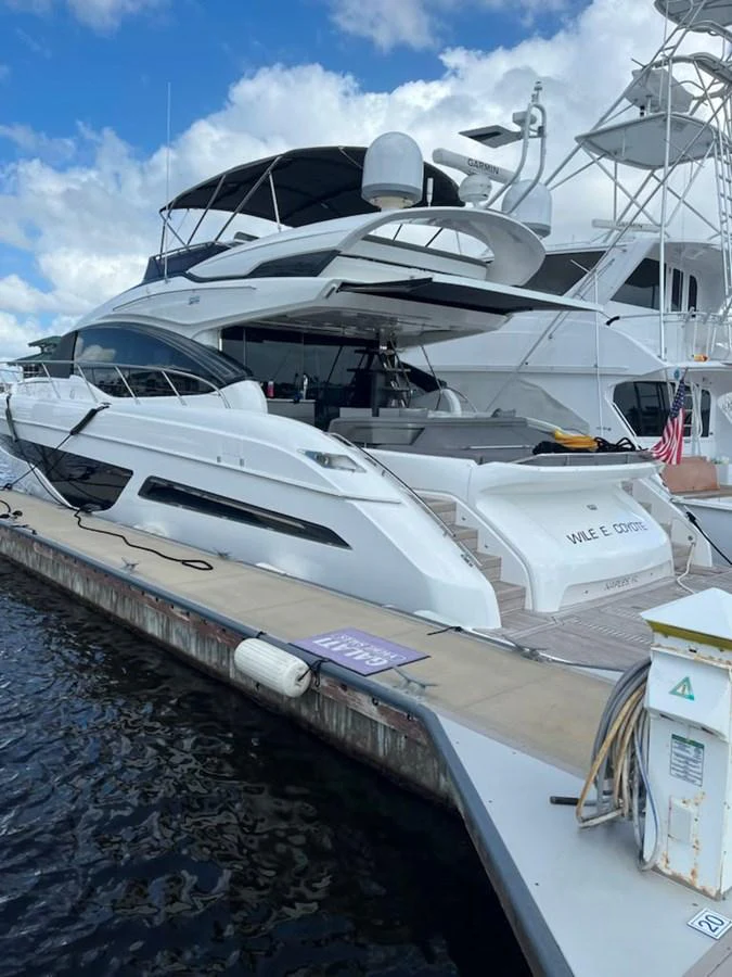 The yacht is docked at a marina, showcasing its sleek and modern design. aboard WILE E COYOTE Yacht for Sale