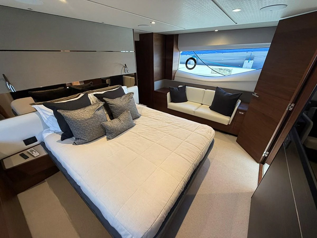 The stateroom features a plush bed with elegant bedding and a cozy seating area by the window. aboard WILE E COYOTE Yacht for Sale