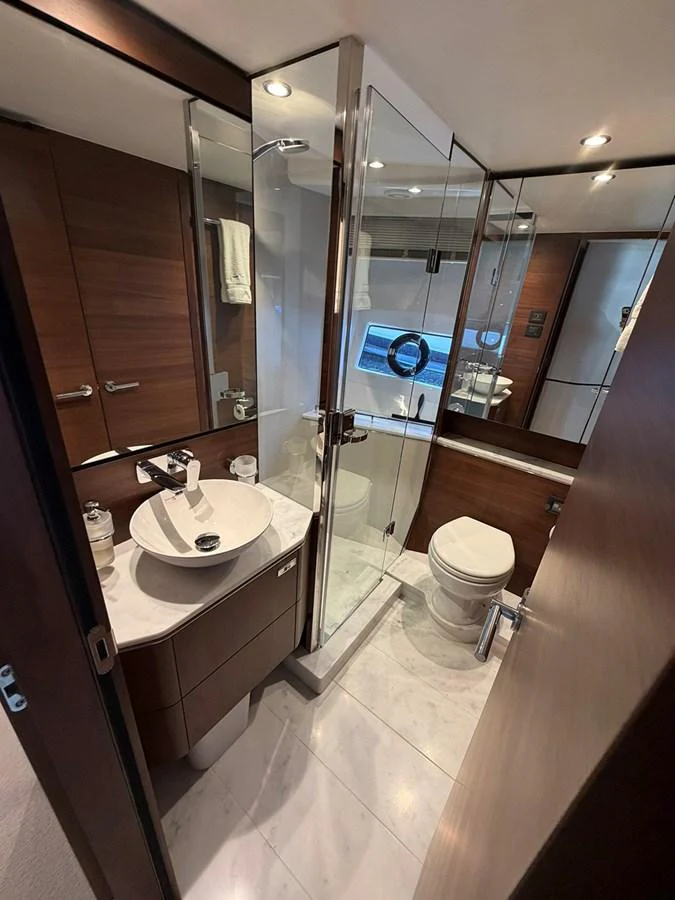 A modern yacht bathroom featuring a sleek design with a glass-enclosed shower and elegant fixtures. aboard WILE E COYOTE Yacht for Sale