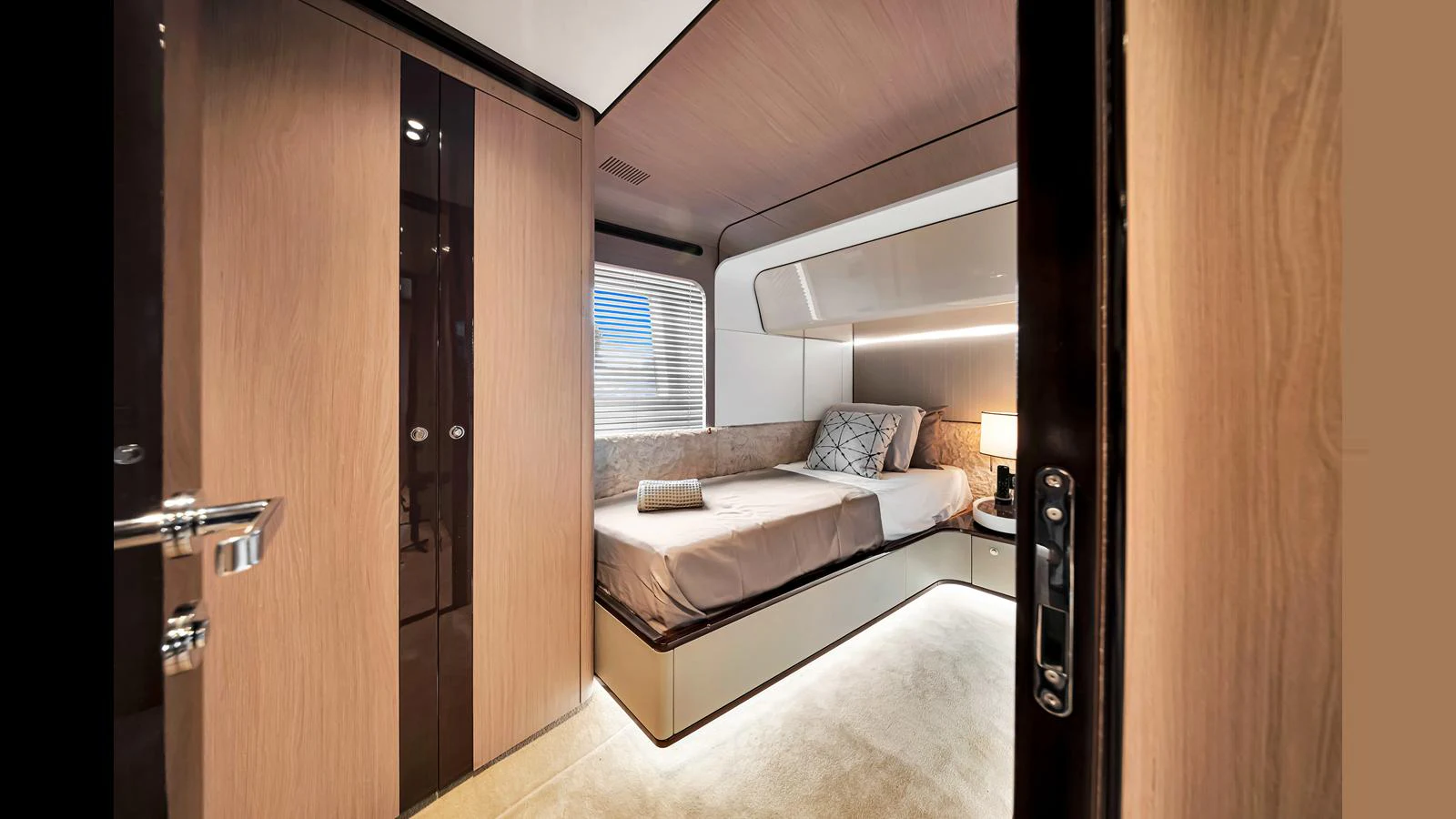 A cozy and modern stateroom with elegant wood finishes and ambient lighting. aboard CLOUD 9 Yacht for Sale