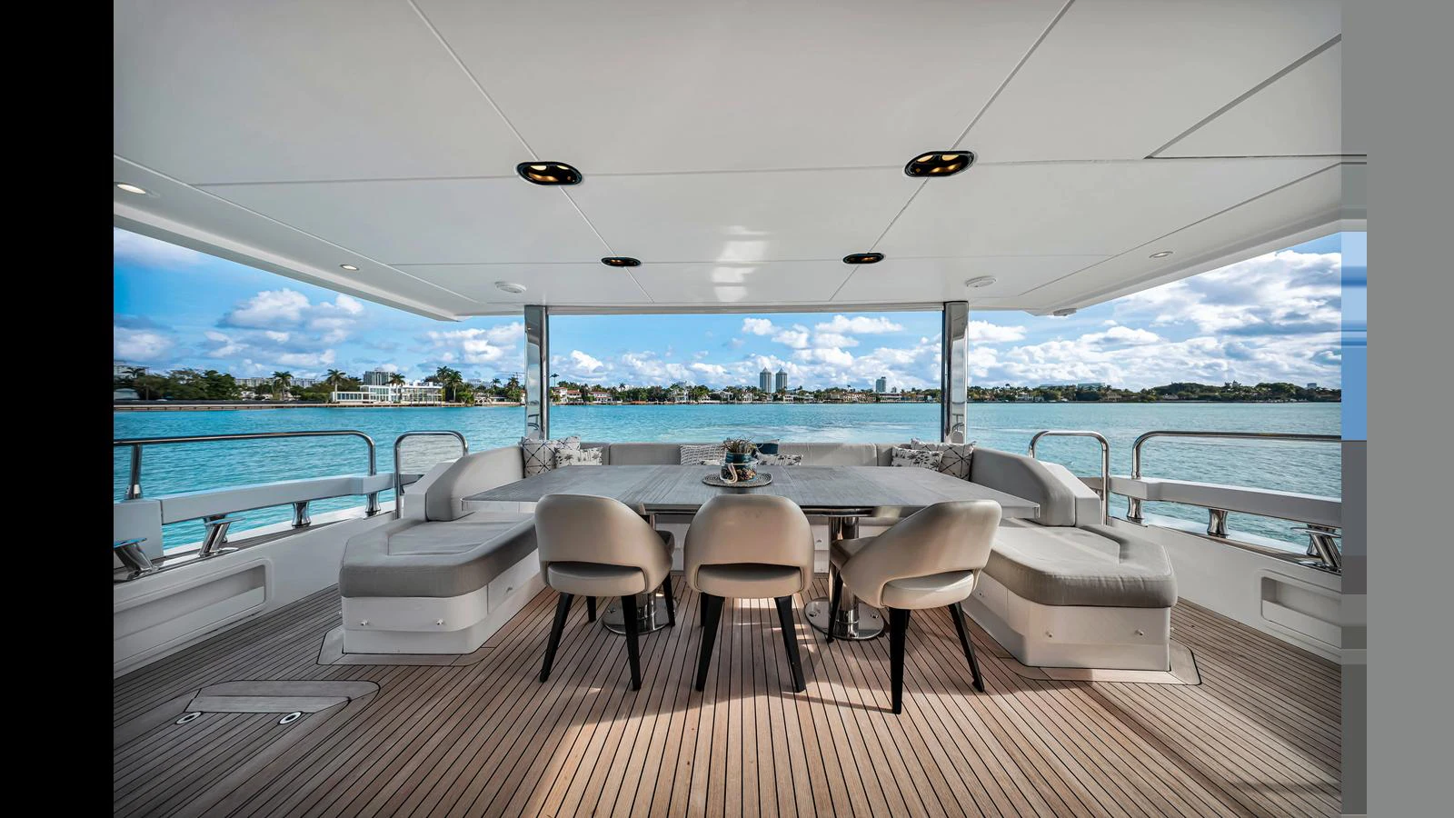 The aft deck features a spacious dining area with a stunning view of the water. aboard CLOUD 9 Yacht for Sale