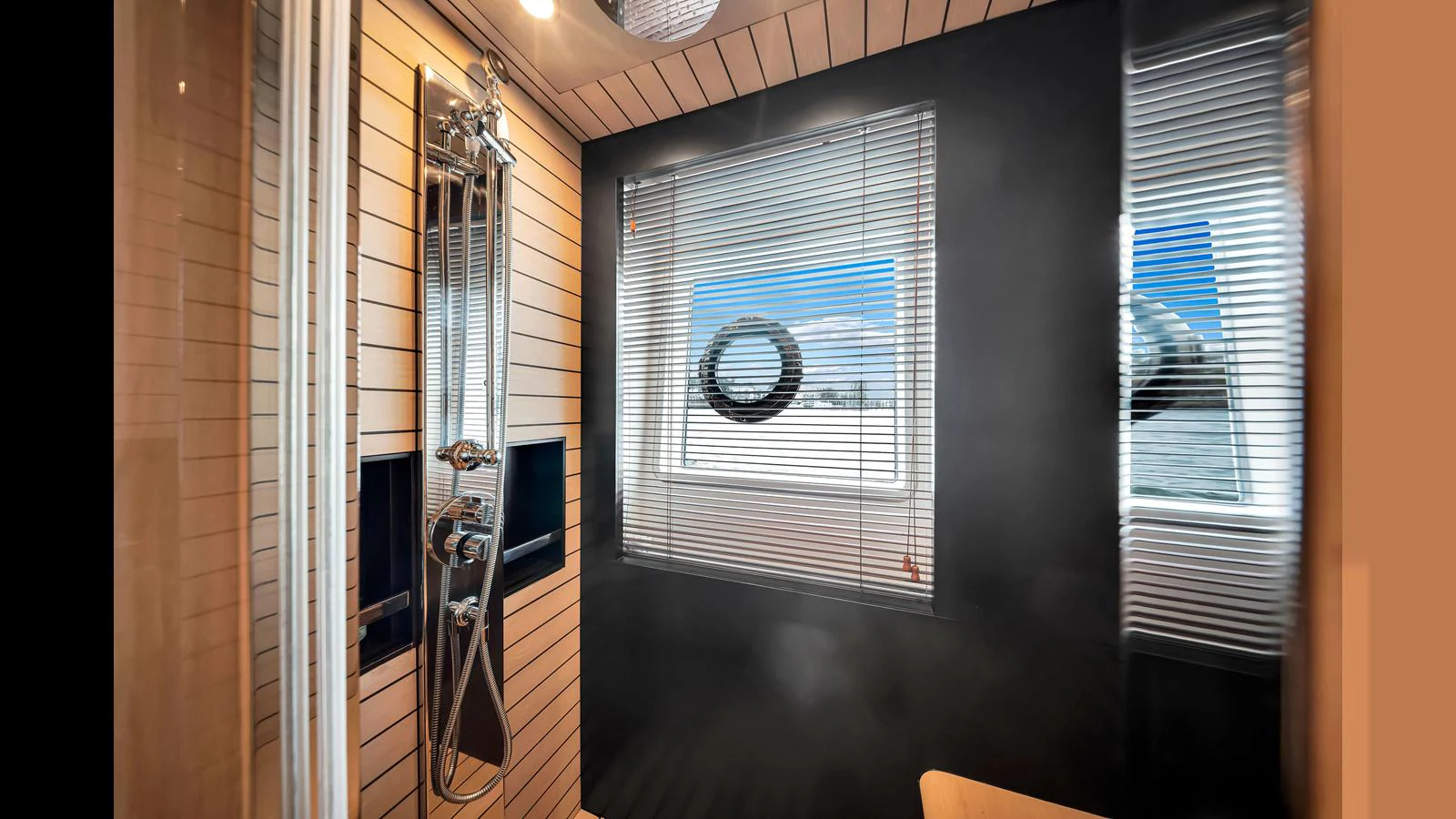 A modern yacht bathroom with sleek fixtures and a window offering a view of the sea. aboard CLOUD 9 Yacht for Sale