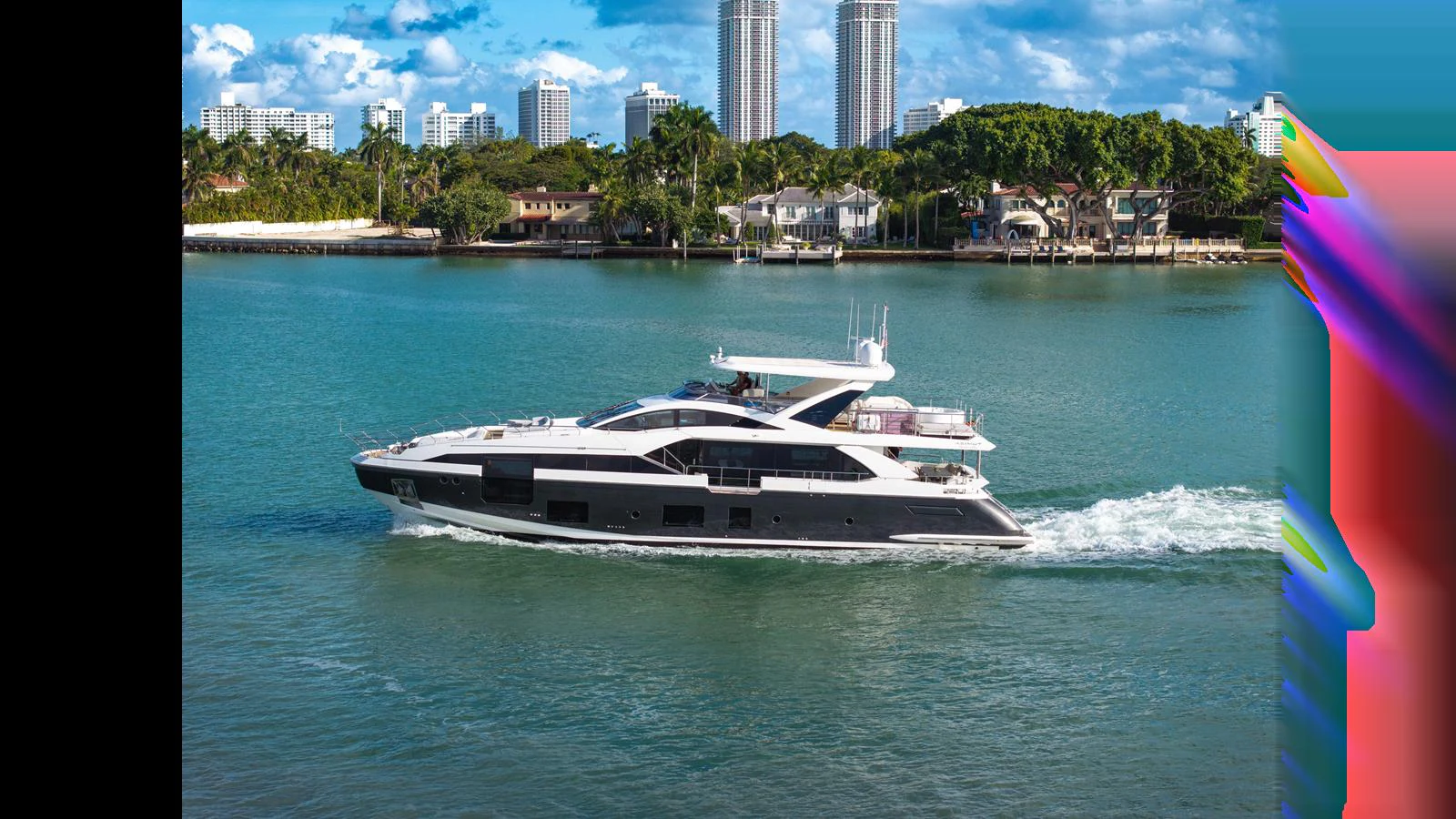 A sleek yacht cruises through calm waters with a cityscape in the background. aboard CLOUD 9 Yacht for Sale