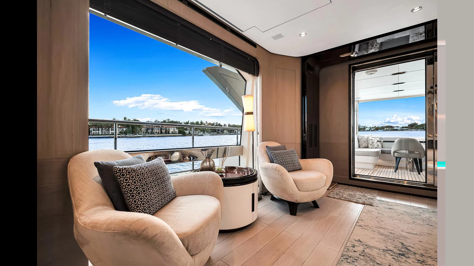 A luxurious yacht interior with plush seating and a stunning view of the water through large windows. aboard CLOUD 9 Yacht for Sale