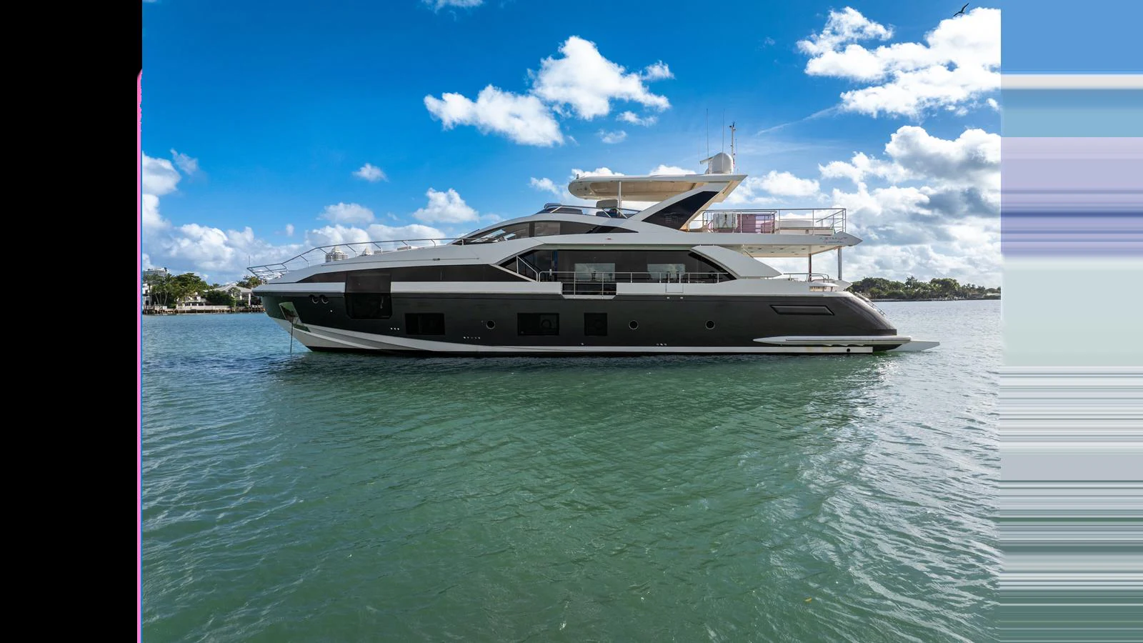 A sleek and modern yacht glides gracefully on calm waters under a bright blue sky. aboard CLOUD 9 Yacht for Sale