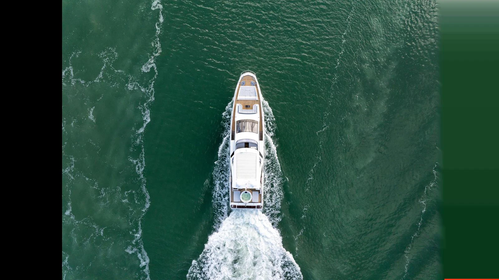 An aerial view of a yacht cruising through the water, leaving a trail of waves behind. aboard CLOUD 9 Yacht for Sale