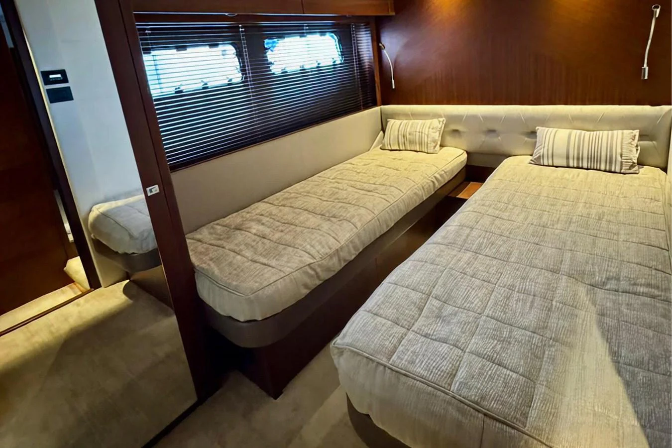 The twin stateroom offers a cozy and comfortable sleeping arrangement with two single beds and elegant wood finishes. aboard LADY N Yacht for Sale