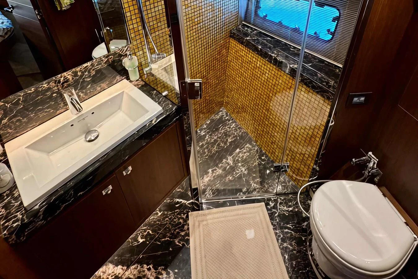 The yacht's bathroom features luxurious marble surfaces and a modern glass-enclosed shower. aboard LADY N Yacht for Sale
