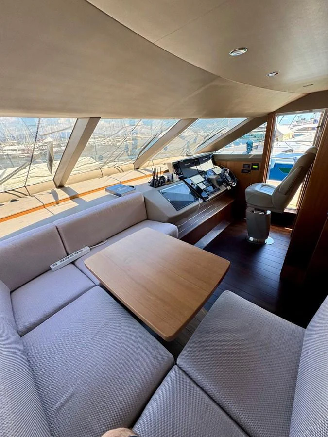 The helm area features a comfortable seating arrangement with a table and advanced navigation equipment. aboard LADY N Yacht for Sale
