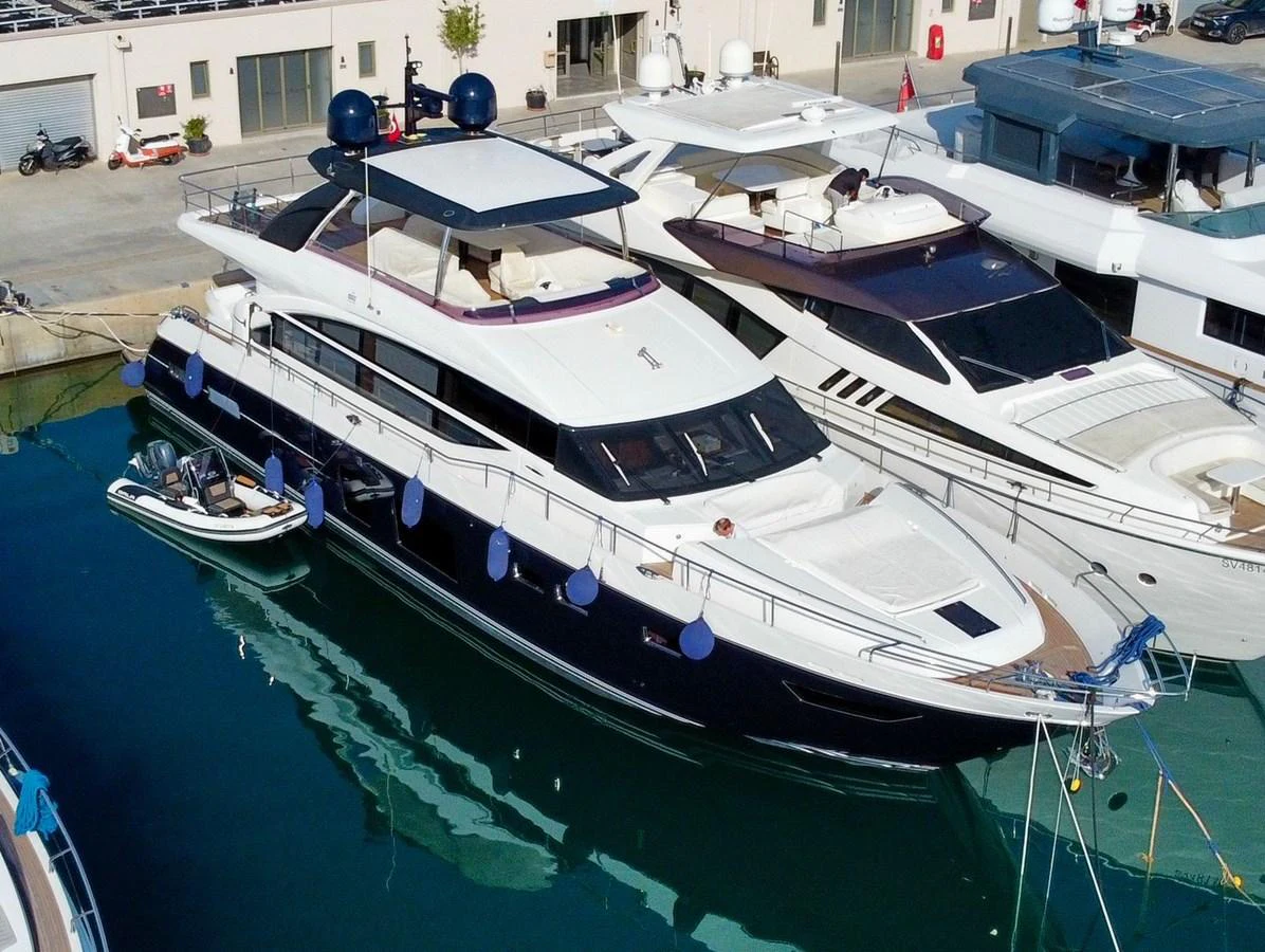 A sleek and modern yacht docked at a marina, showcasing its elegant design and spacious deck areas. aboard LADY N Yacht for Sale