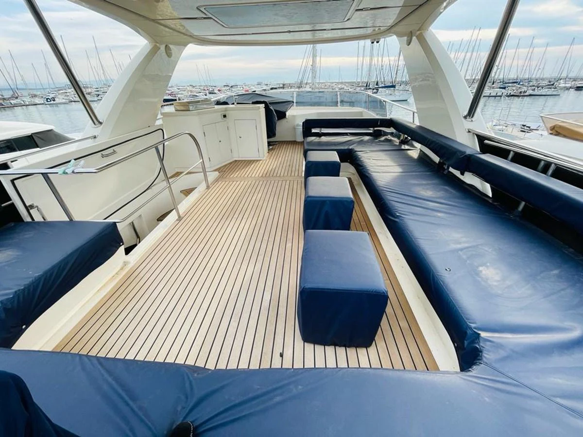 The aft deck features spacious seating with a sleek, modern design and a view of the marina. aboard ASB Yacht for Sale