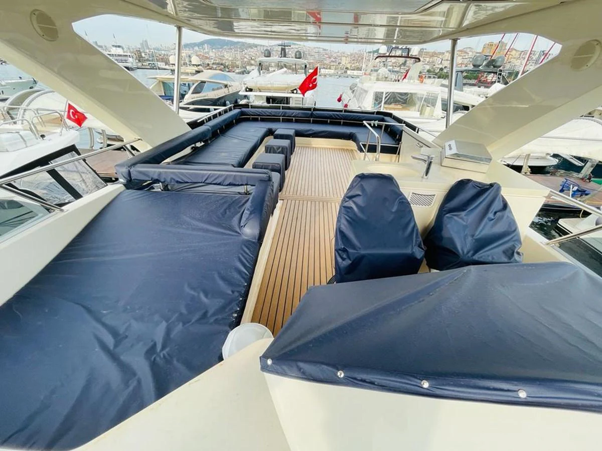 The flybridge offers ample seating and lounging space with a view of the marina. aboard ASB Yacht for Sale