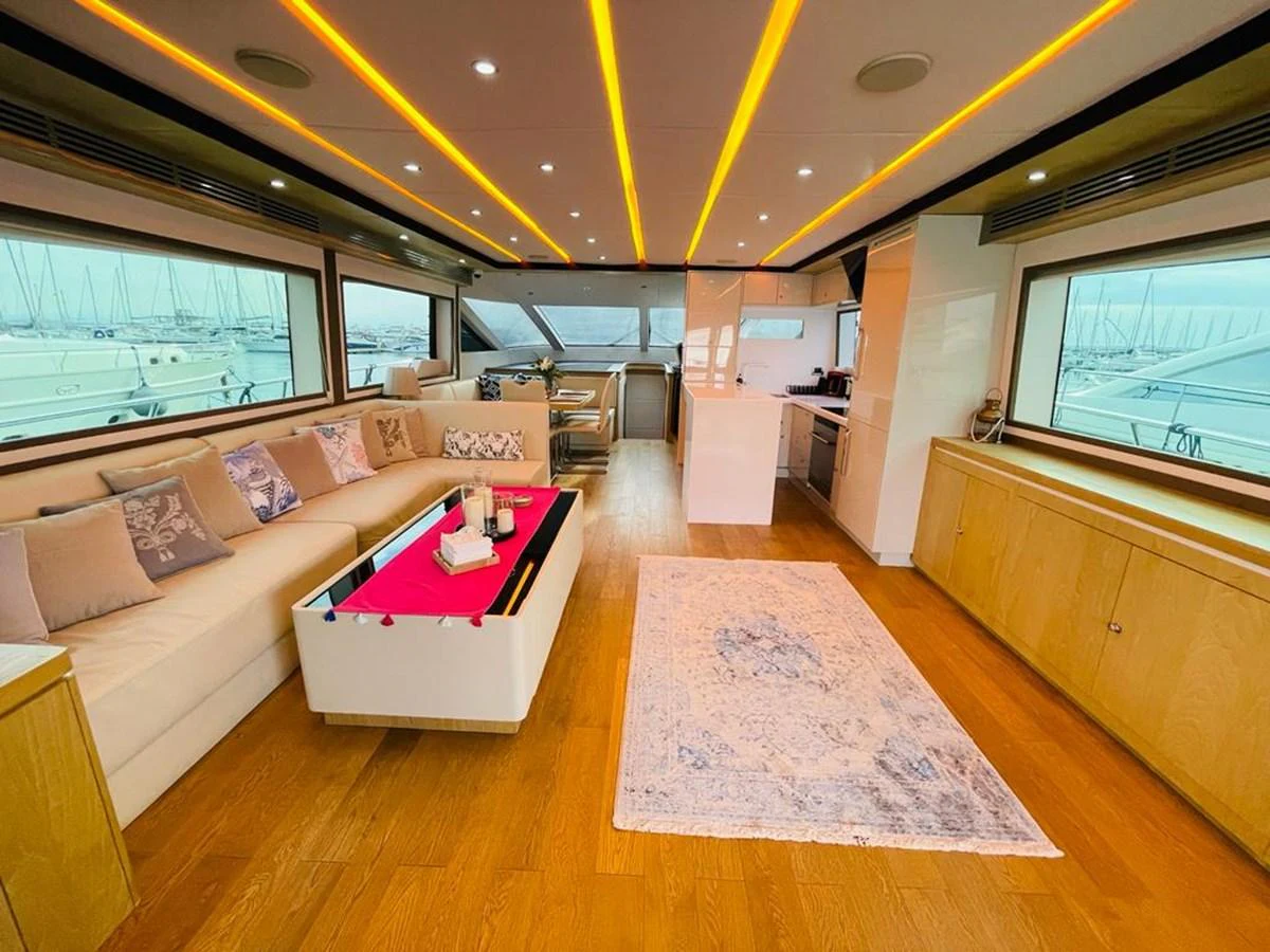 The yacht's salon features a spacious and modern design with ample seating and large windows offering stunning marina views. aboard ASB Yacht for Sale
