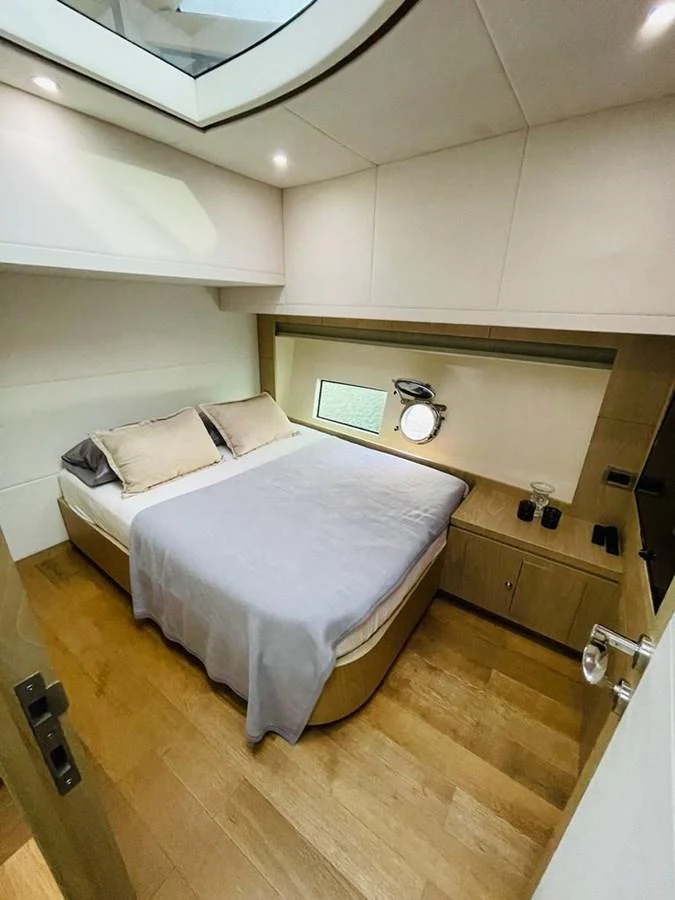 The stateroom features a cozy bed with soft lighting and modern furnishings. aboard ASB Yacht for Sale