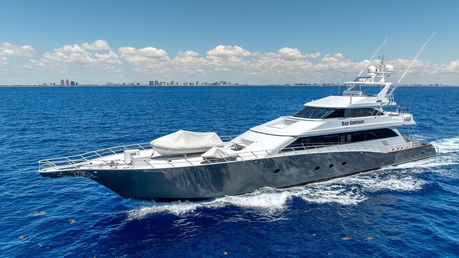 A sleek and modern yacht cruising on the open sea under a clear blue sky. aboard BAD COMPANY Yacht for Sale