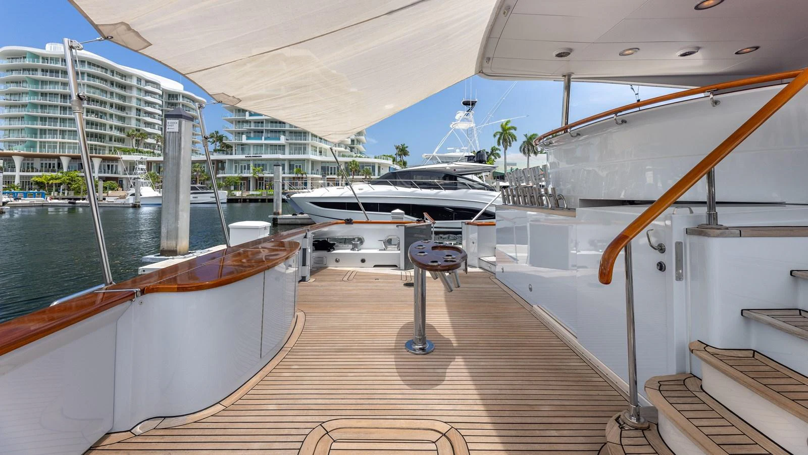The aft deck offers a spacious and inviting area for relaxation and socializing, with elegant wooden flooring and a shaded canopy. aboard BAD COMPANY Yacht for Sale