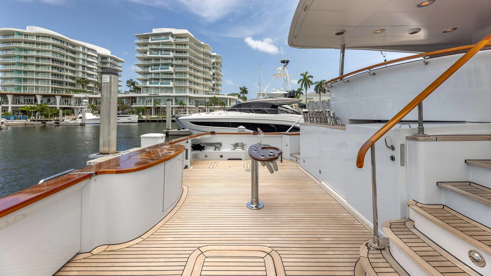 The yacht's aft deck features elegant teak flooring and polished railings, offering a stylish and inviting outdoor space. aboard BAD COMPANY Yacht for Sale