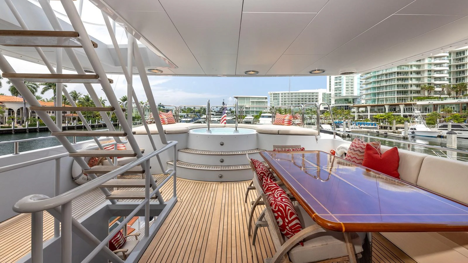 The aft deck features a spacious dining area with a polished wooden table and comfortable seating, perfect for alfresco dining. aboard BAD COMPANY Yacht for Sale