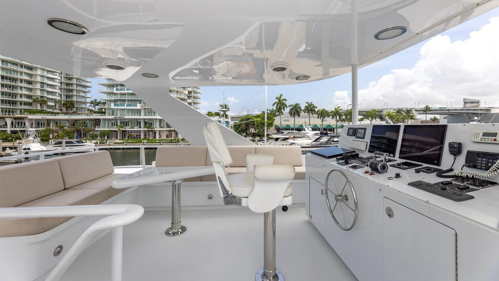 The helm area features modern navigation equipment and comfortable seating with a view of the marina. aboard BAD COMPANY Yacht for Sale