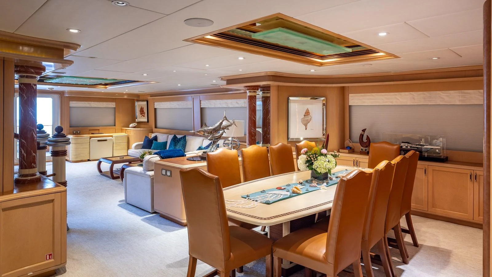 The yacht's dining area features a luxurious table with leather chairs, complemented by a comfortable lounge space. aboard BAD COMPANY Yacht for Sale