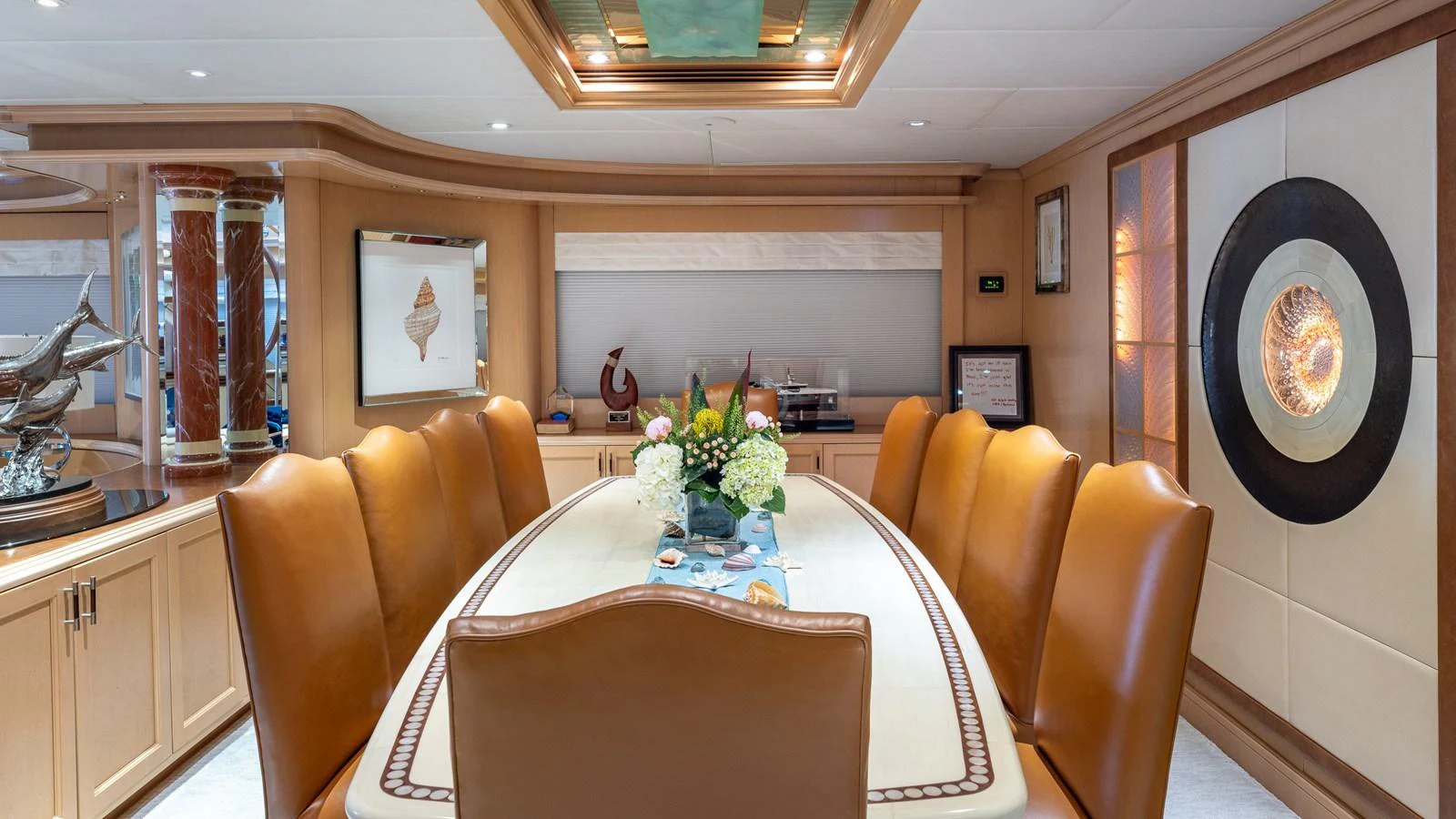 The yacht's dining area features a luxurious table with plush leather chairs and elegant decor. aboard BAD COMPANY Yacht for Sale