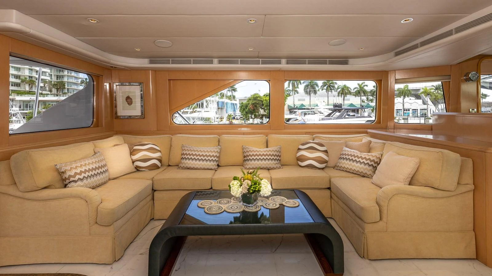 The salon features a spacious and comfortable seating area with large windows offering a view of the marina. aboard BAD COMPANY Yacht for Sale