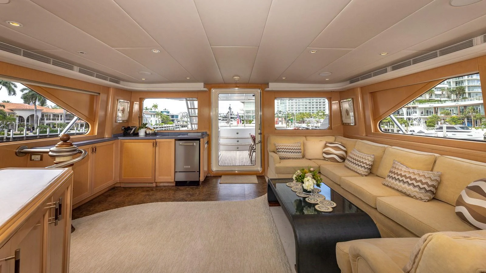 The salon offers a spacious and inviting area with ample seating and large windows providing a view of the marina. aboard BAD COMPANY Yacht for Sale