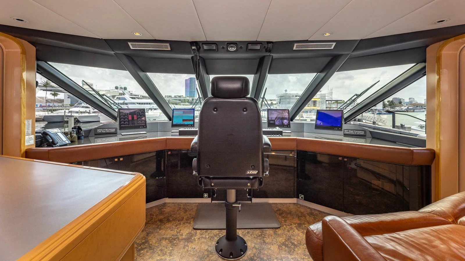 The helm station offers a commanding view with advanced navigation equipment and luxurious seating. aboard BAD COMPANY Yacht for Sale