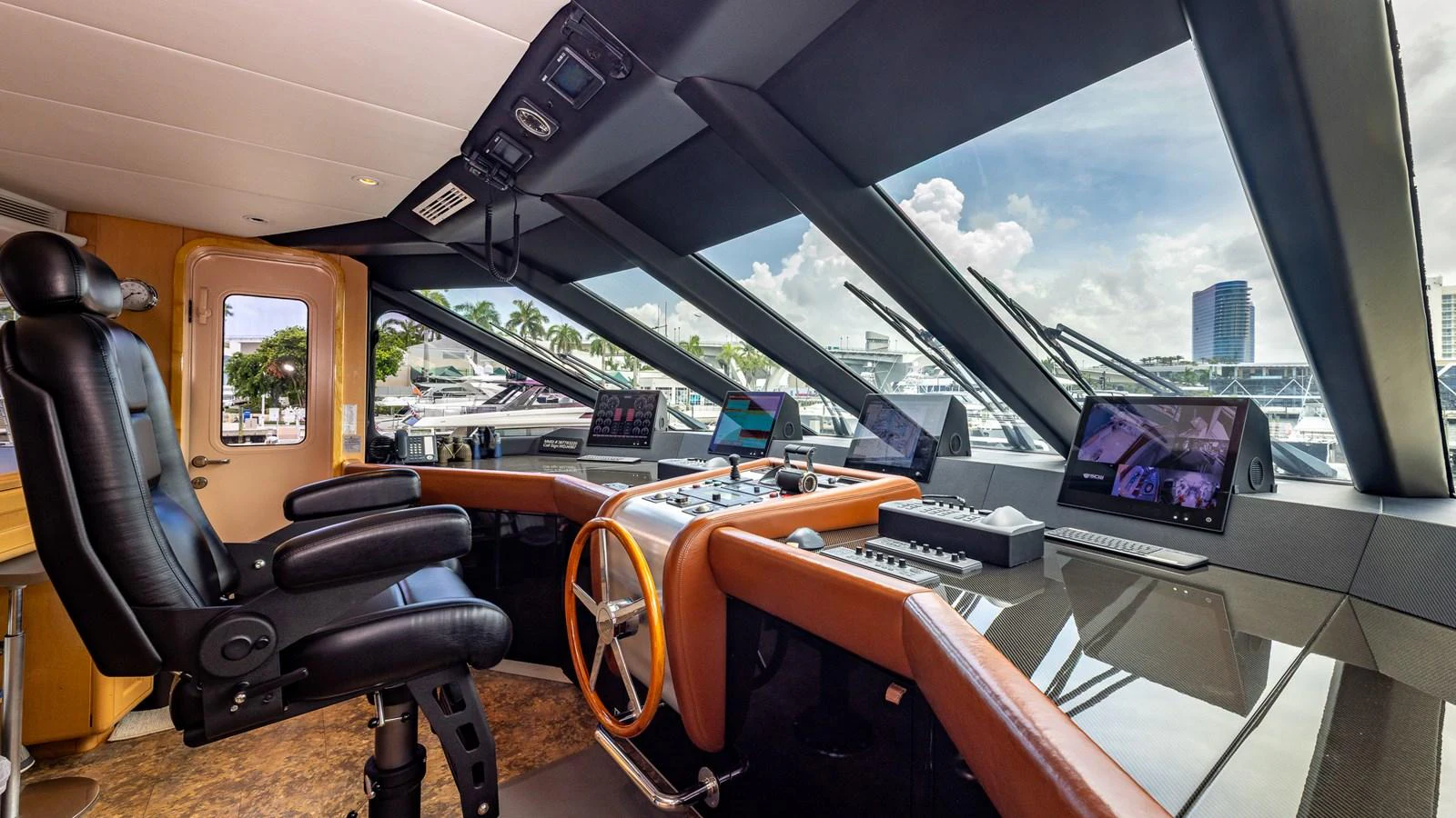 The helm station features advanced navigation equipment and a luxurious captain's chair, offering a commanding view through large windows. aboard BAD COMPANY Yacht for Sale