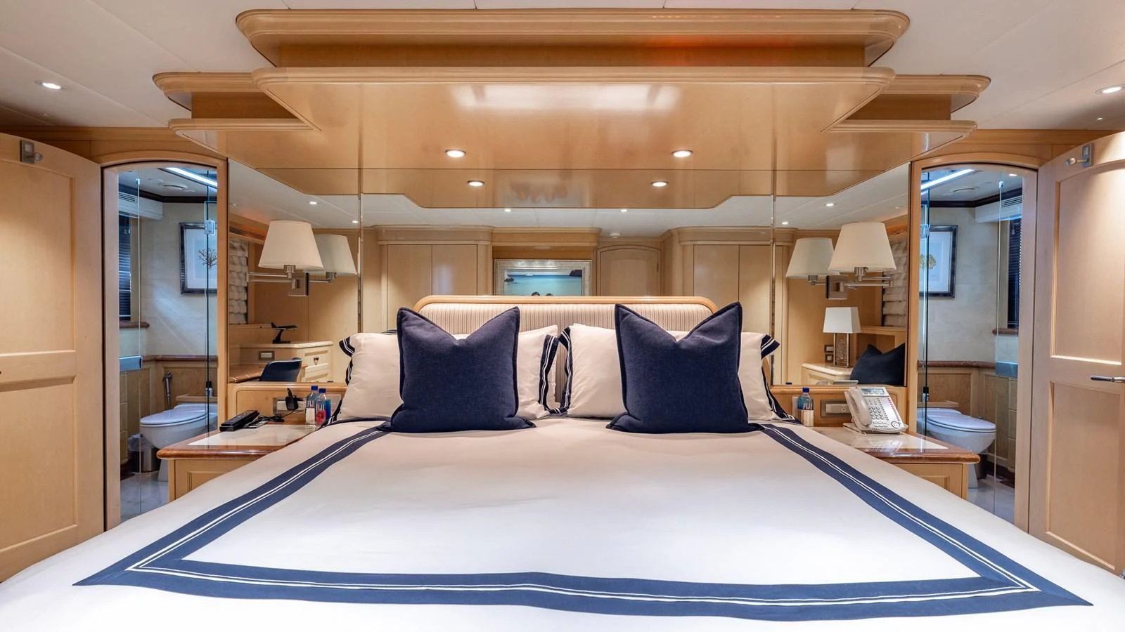 The master stateroom features a luxurious bed with elegant bedding and ample natural light. aboard BAD COMPANY Yacht for Sale