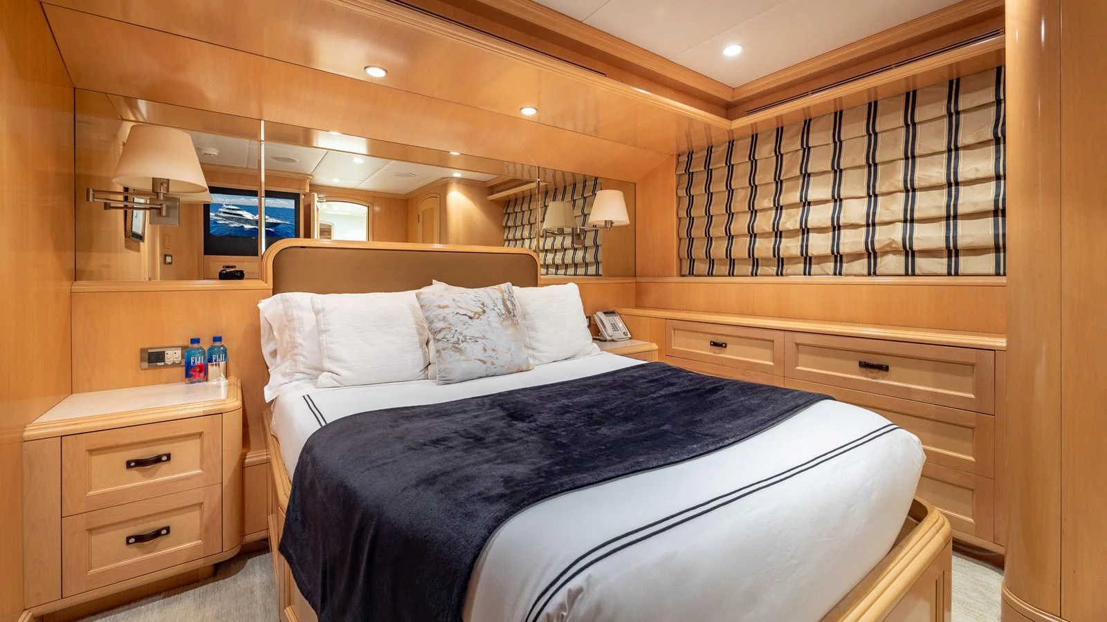 The stateroom features a plush bed with elegant wood finishes and ample storage. aboard BAD COMPANY Yacht for Sale