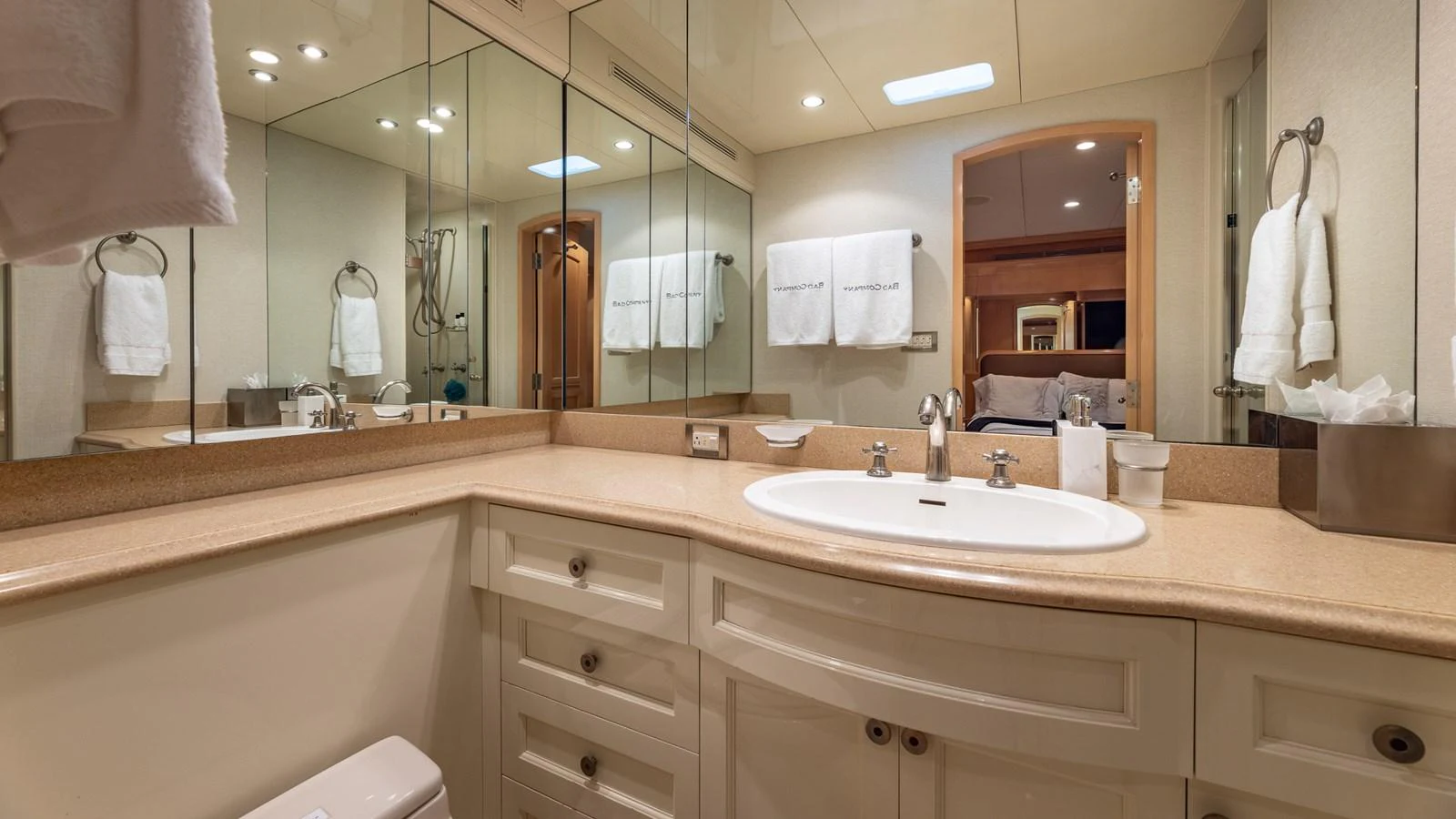 The yacht's bathroom features a spacious vanity with a large mirror and elegant fixtures. aboard BAD COMPANY Yacht for Sale