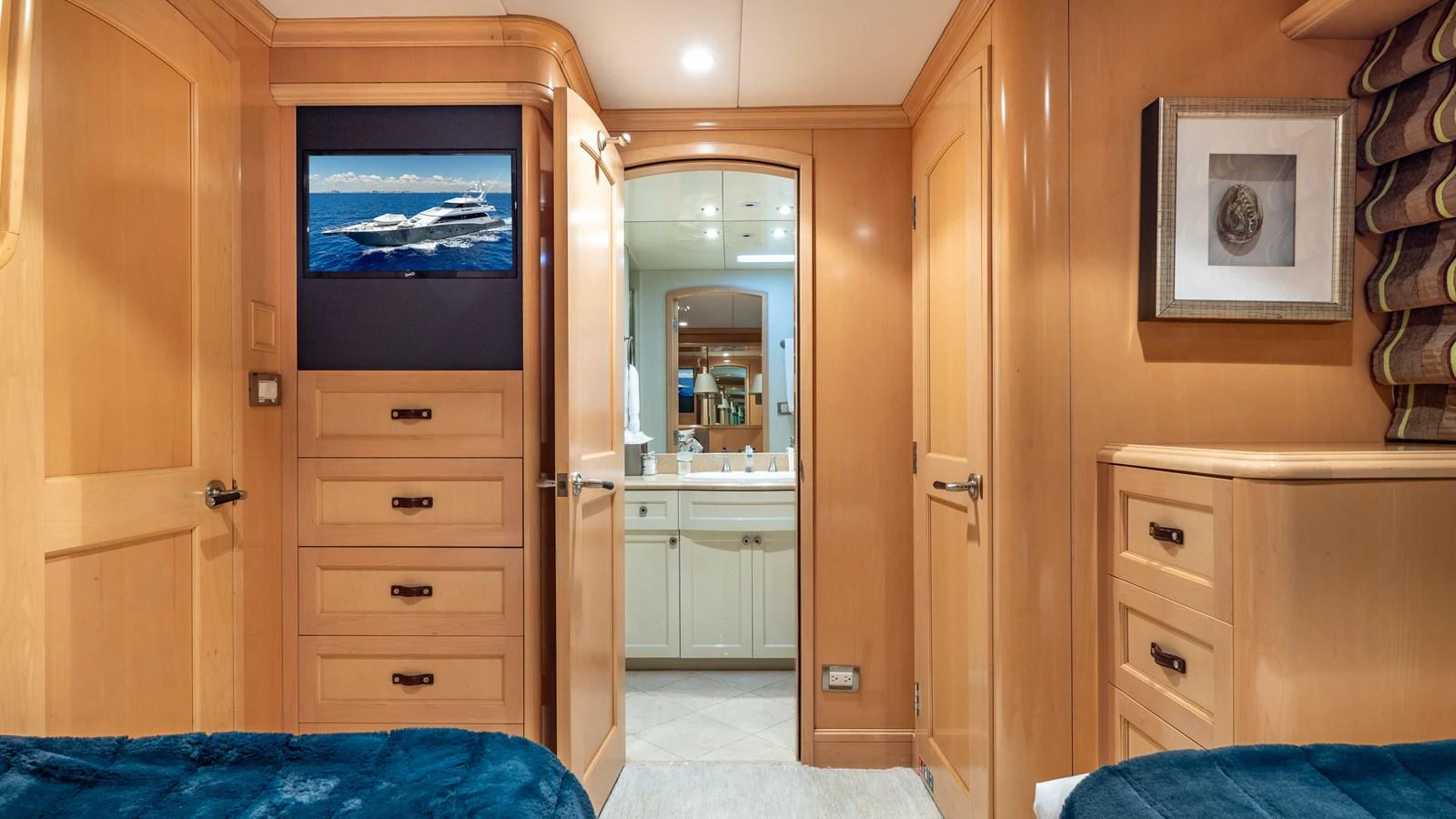 The cozy interior features a view into a well-appointed bathroom, with warm wood tones and a touch of luxury. aboard BAD COMPANY Yacht for Sale