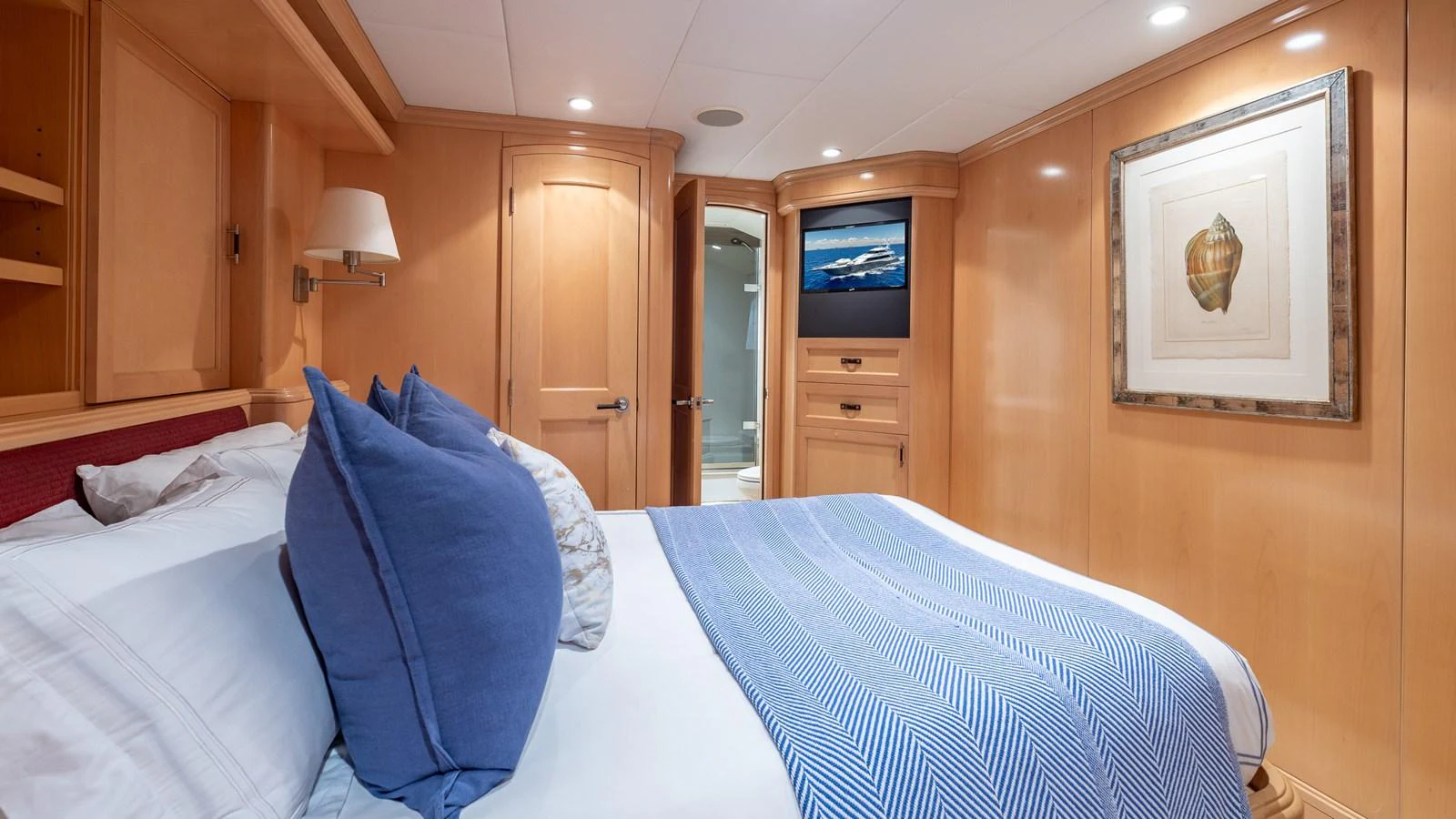 This cozy stateroom features a comfortable bed with plush pillows and elegant wooden cabinetry. aboard BAD COMPANY Yacht for Sale