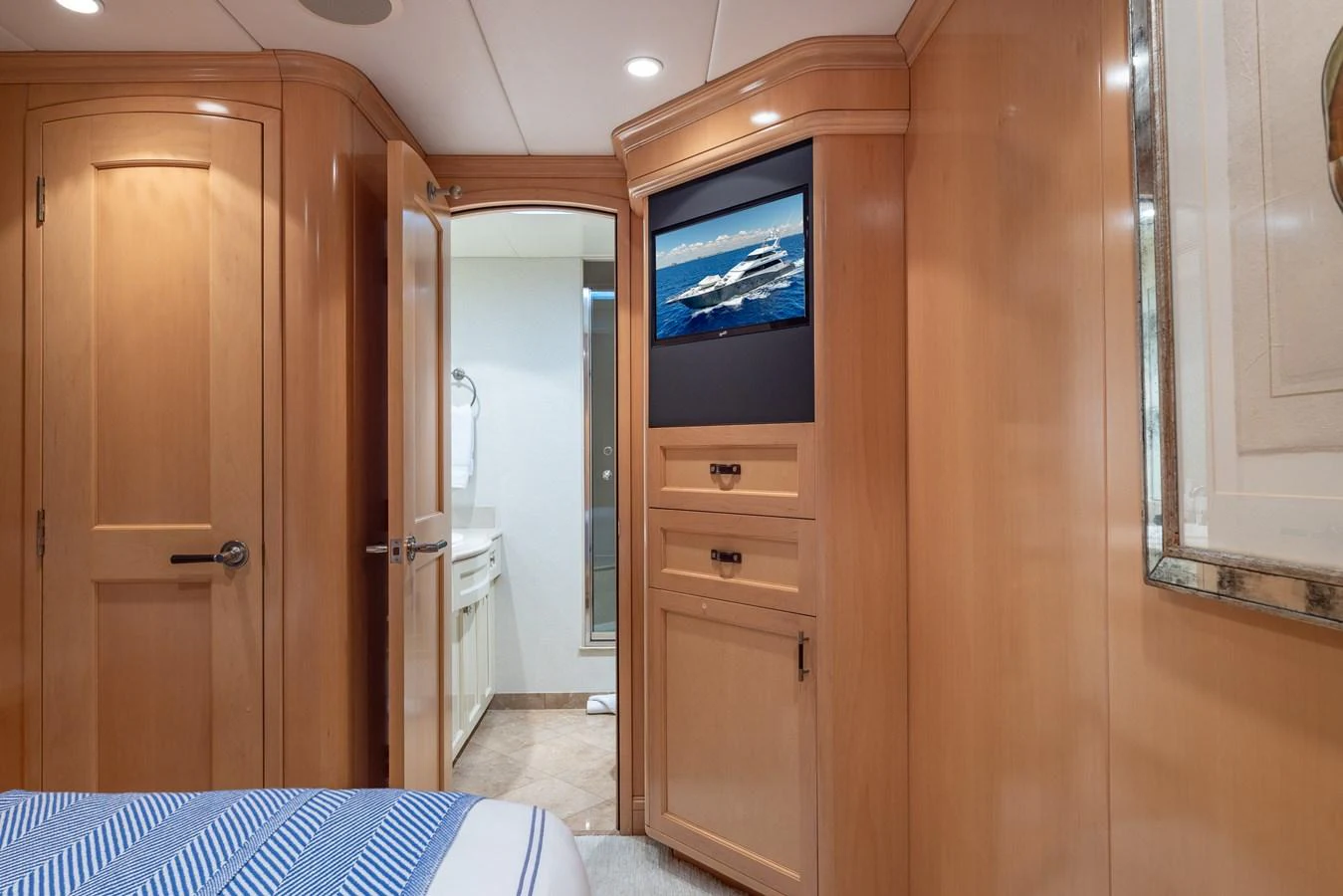 The stateroom features elegant wood paneling and a built-in entertainment system. aboard BAD COMPANY Yacht for Sale