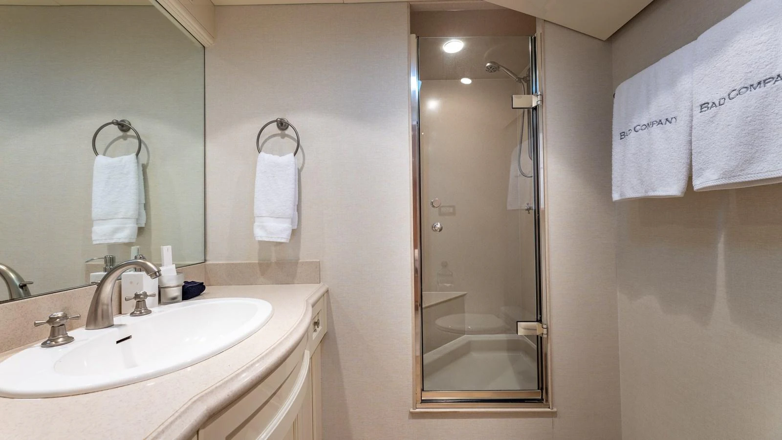 A pristine yacht bathroom featuring a glass-enclosed shower and elegant fixtures. aboard BAD COMPANY Yacht for Sale