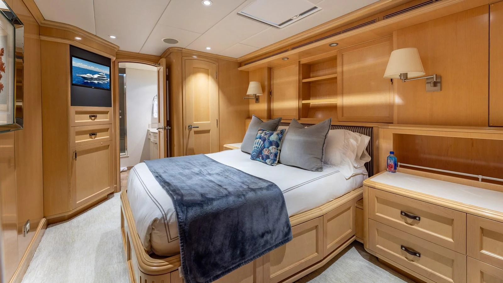 The stateroom features a luxurious bed with elegant wooden cabinetry and modern lighting. aboard BAD COMPANY Yacht for Sale