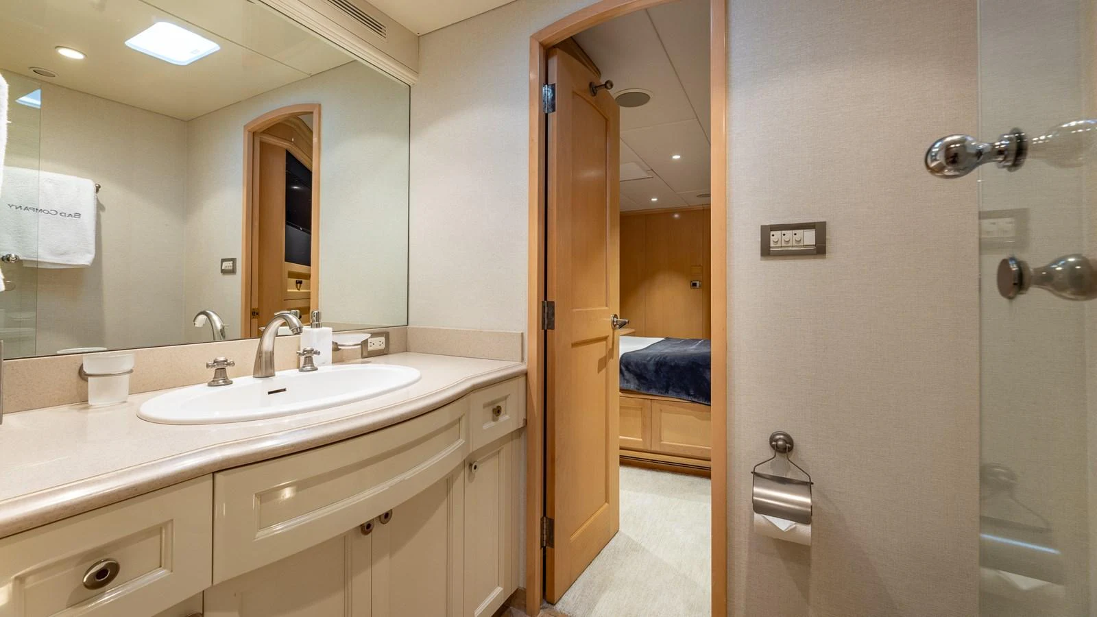 The yacht's bathroom features a sleek vanity with a large mirror and modern fixtures. aboard BAD COMPANY Yacht for Sale