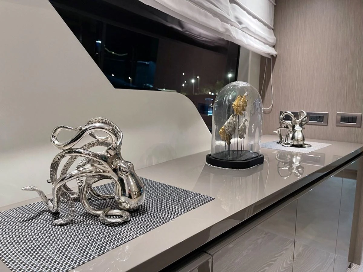 A stylish interior detail featuring elegant metallic sculptures and a glass dome with preserved flowers. aboard FOUZ Yacht for Sale