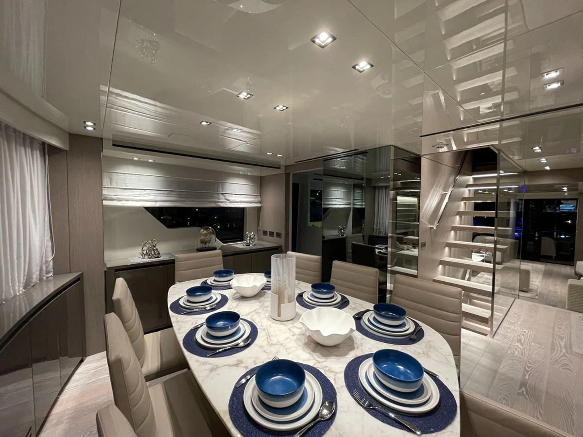 The yacht's dining area features a sophisticated setting with a modern table and elegant place settings. aboard FOUZ Yacht for Sale